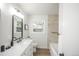 Bright bathroom with black hardware, tiled shower, window and a white vanity at 1809 W Crestline Dr, Littleton, CO 80120
