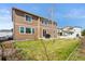 A grassy back yard has a grill on the patio and a two-story home with tan siding at 20145 E Fair Ln, Centennial, CO 80016