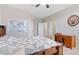 Spacious bedroom with a wooden bed frame, ceiling fan, and natural light at 20145 E Fair Ln, Centennial, CO 80016