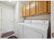 Functional laundry room with washer, dryer, and overhead cabinets for storage at 9214 Winona Ct, Westminster, CO 80031