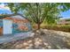 Spacious backyard featuring a large shade tree and colorful mural on the garage at 1401 Ash St, Denver, CO 80220