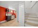 Basement kitchenette featuring modern cabinetry, shelving, and mini fridge next to stairway at 1401 Ash St, Denver, CO 80220