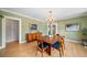 Green dining room with hardwood floors, a chandelier, and wood furniture at 1401 Ash St, Denver, CO 80220