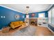 Elegant living room featuring bright blue walls, a decorative fireplace, built-in shelving, and hardwood floors at 1401 Ash St, Denver, CO 80220