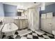 Basement bathroom with checkered tile floors, clawfoot tub and wainscoting at 1265 Saint Paul St, Denver, CO 80206