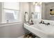 Bathroom featuring a classic sink, large mirror, and natural light from the window at 1265 Saint Paul St, Denver, CO 80206