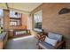 Charming front porch with a swing, chair, and brick accents at 1265 Saint Paul St, Denver, CO 80206