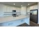 Modern kitchen with white cabinetry, stainless steel appliances, and a spacious island at 767 Raindance St, Erie, CO 80516