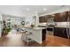 Open concept kitchen with granite counters, dark cabinets, and stainless steel appliances, connected to living room at 480 E Fremont Pl # 308, Centennial, CO 80122
