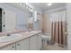 Bright bathroom with double sinks and shower-tub combination with a pink-and-white shower curtain at 329 Bobcat Pt, Lafayette, CO 80026