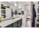 Well-lit bathroom featuring gray vanity, granite counters, and access to the bedroom, a convenient and stylish setup at 4100 Albion St # 221, Denver, CO 80216