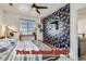 A bright bedroom boasts a ceiling fan, a patterned accent wall, a window, and stylish decor at 4100 Albion St # 221, Denver, CO 80216