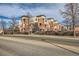 Apartment building with brick and tan siding and balconies next to a street at 4100 Albion St # 221, Denver, CO 80216