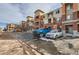 Apartment complex with brick and tan siding, balconies, parked cars, and parking spaces at 4100 Albion St # 221, Denver, CO 80216
