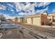 Row of garages with an apartment building in the background on a partly cloudy day at 4100 Albion St # 221, Denver, CO 80216