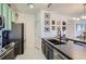 A modern kitchen features stainless steel appliances, dark countertops, mint-green cabinetry, and a stylish dining area at 4100 Albion St # 221, Denver, CO 80216