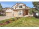 Two-story home featuring a three-car garage, manicured lawn, and a welcoming entrance at 165 Washington St, Golden, CO 80403