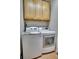 Modern laundry room features white front-load washer/dryer units and light wood cabinets for convenient storage at 165 Washington St, Golden, CO 80403