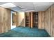 Basement with wood paneling and carpeted floor, providing versatile space for various uses at 11884 Elk Head Range Rd, Littleton, CO 80127
