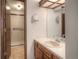Well-lit bathroom with a single sink vanity and walk-in shower with tile surround and glass door at 11884 Elk Head Range Rd, Littleton, CO 80127