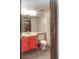 Bathroom featuring bright red vanity, toilet, and large mirror at 11884 Elk Head Range Rd, Littleton, CO 80127