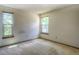 Bright bedroom featuring two windows and neutral carpet, offering a blank canvas for personalization at 11884 Elk Head Range Rd, Littleton, CO 80127