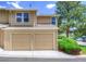 Exterior view of the townhouse with garages, landscaping, and street parking at 11884 Elk Head Range Rd, Littleton, CO 80127
