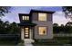 Charming two-story home featuring a modern design, dark siding, brick accents, and a well-manicured front lawn at 7251 Goldbloom Ln, Littleton, CO 80125