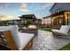 Inviting backyard with a stone fire pit, modern seating, a covered patio, and lush green landscaping at 27250 E Nova Cir, Aurora, CO 80016