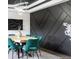 Dining room with teal chairs, modern lighting, wood table, and geometric wall paneling at 27250 E Nova Cir, Aurora, CO 80016
