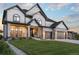 Beautiful two-story home with gray siding, stone accents, a well-manicured lawn, and a basketball hoop on driveway at 27250 E Nova Cir, Aurora, CO 80016