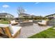 Outdoor fire pit with stone surround and ample seating creating a cozy backyard gathering space at 27250 E Nova Cir, Aurora, CO 80016