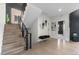 Bright foyer with wood stairs, iron railings, shiplap accent wall, and stylish bench seating at 27250 E Nova Cir, Aurora, CO 80016
