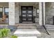 Charming front entrance with a double front door, stone columns, and a cozy seating area at 27250 E Nova Cir, Aurora, CO 80016