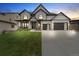 Beautiful two-story home with a well-manicured lawn, stone accents, and a modern garage door design at 27250 E Nova Cir, Aurora, CO 80016