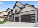 Close-up of the home's exterior, featuring stone accents, black trim, and a modern garage door design at 27250 E Nova Cir, Aurora, CO 80016