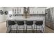 Modern kitchen with white cabinetry, a large island with bar stools, and stainless steel appliances at 27250 E Nova Cir, Aurora, CO 80016