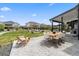 Expansive stone patio with dining and lounge areas overlooking the beautifully landscaped backyard and fire pit at 27250 E Nova Cir, Aurora, CO 80016
