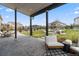 Spacious covered patio featuring an outdoor lounge area and view of the backyard and fire pit at 27250 E Nova Cir, Aurora, CO 80016