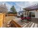 Large backyard deck with dining area, plus dog house and fenced yard at 1190 Glencoe St, Denver, CO 80220