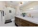 Modern bathroom featuring a double vanity with marble countertop and a glass-enclosed shower with gold hardware at 1190 Glencoe St, Denver, CO 80220