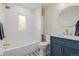 Stylish bathroom featuring a tub, marble countertop, and a round mirror providing comfort and design at 1190 Glencoe St, Denver, CO 80220
