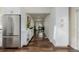 Hallway with a full size stainless steel refrigerator and hardwood floors at 1190 Glencoe St, Denver, CO 80220