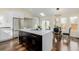 New kitchen with a large island and stainless steel refrigerator at 1190 Glencoe St, Denver, CO 80220