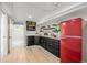 Functional kitchenette with black cabinets, a red refrigerator, and laminate floors for a basement at 1190 Glencoe St, Denver, CO 80220