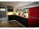 Charming kitchenette with black cabinets, a retro red refrigerator, and open shelving, perfect for entertaining at 1190 Glencoe St, Denver, CO 80220