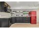 Practical kitchenette with black cabinets, a retro refrigerator, and open shelving, perfect for small snacks at 1190 Glencoe St, Denver, CO 80220