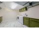 Well-equipped laundry room with marble floors, stylish green cabinets, and modern appliances at 1190 Glencoe St, Denver, CO 80220