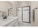 Bright bathroom with white cabinets, countertop, and modern black framed glass shower at 2766 Keepsake Way, Castle Rock, CO 80109