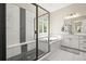 Modern bathroom with a glass-enclosed shower, soaking tub, and elegant black and white tiling at 2766 Keepsake Way, Castle Rock, CO 80109